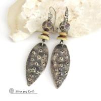 These handcrafted sterling silver earrings have a funky edgy vibe. They feature rustic hammered sterling silver dangles accented with natural asteroid jasper stones and bone beads. This type of stone is known for its unique dotted matrix in earth-tone hues of brown, gray and tan. It's also known as chocolate ocean jasper because it's found on the shores of Madagascar where ocean jasper is also found.