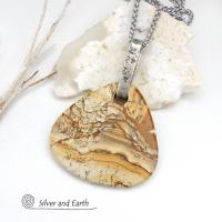 This one-of-a-kind necklace features a large stunning picture jasper stone accented with a handcrafted sterling silver bail. The stone has a beautiful natural pattern in various shades of brown, beige and gray. Big and bold, this necklace is a real statement piece - perfect for anyone that loves natural stones! It's reversible and can be worn on either side. (See all photos for alternate sides).