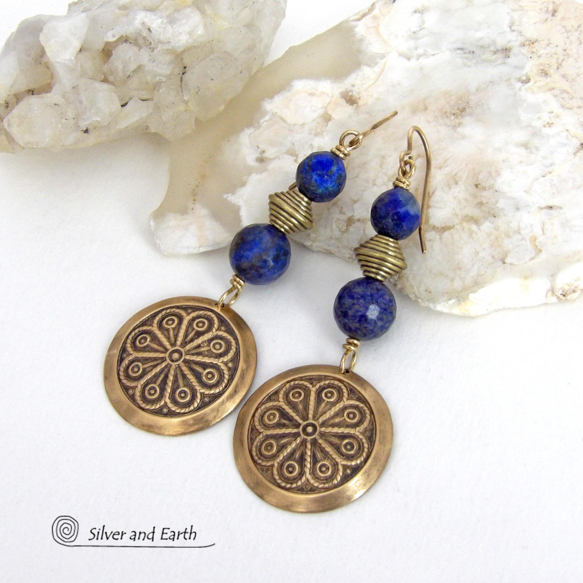 These handcrafted gold brass earrings have an exotic, Egyptian inspired vibe. They feature brass circle dangles with a beautiful embossed texture accented with faceted genuine lapis lazuli gemstones and textured brass beads. Bold and unique, they'll add a touch of cultural exotic charm to any type of wardrobe - dressed up or down. Perfect for women that love unique artisan handcrafted jewelry. Handmade in the USA by Silver and Earth Jewelry. 