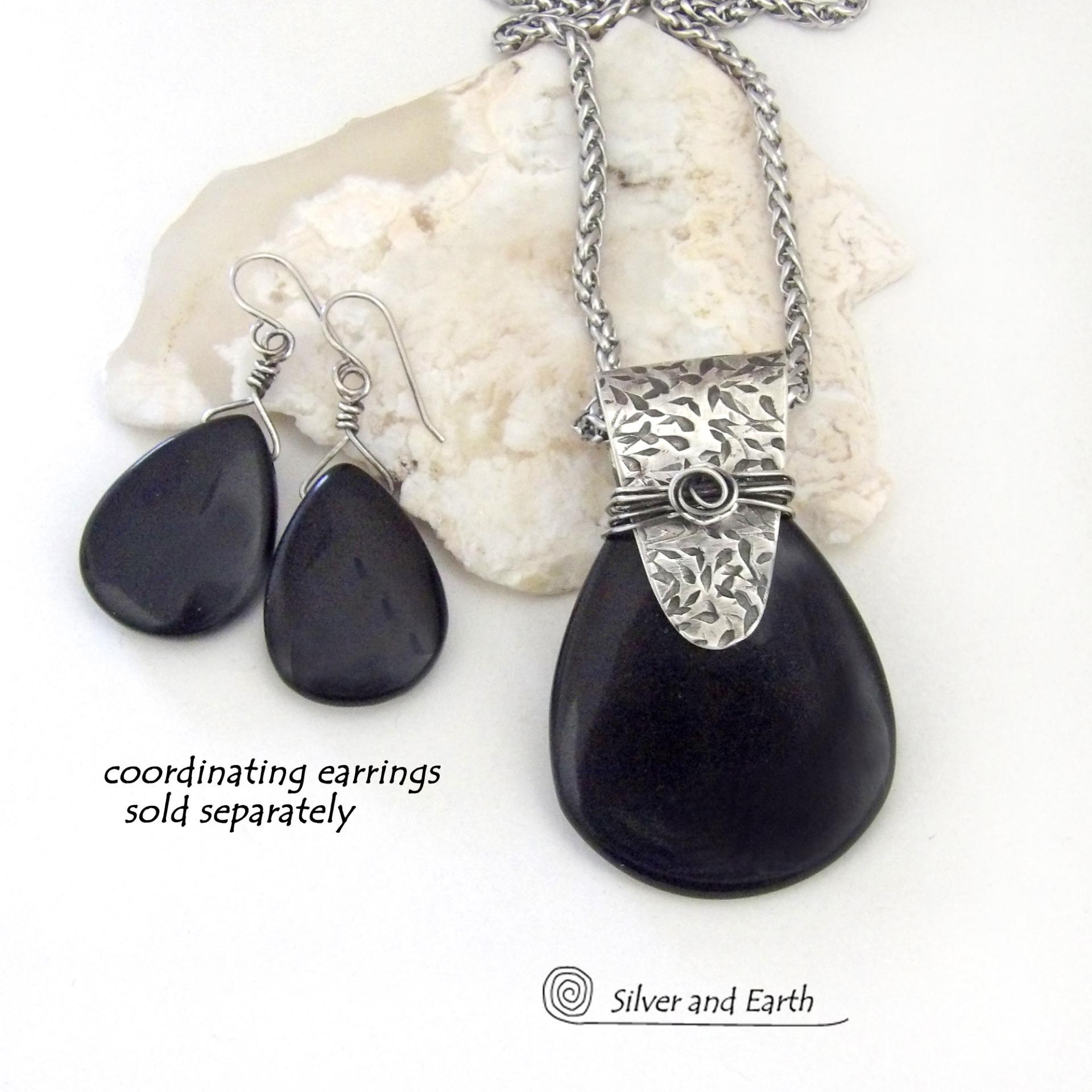 This sterling silver necklace features a black onyx gemstone accented with a handcrafted sterling silver bail with a hand stamped texture. It has a modern, contemporary style that coordinates beautifully with all wardrobe types. Coordinating earrings sold separately. 