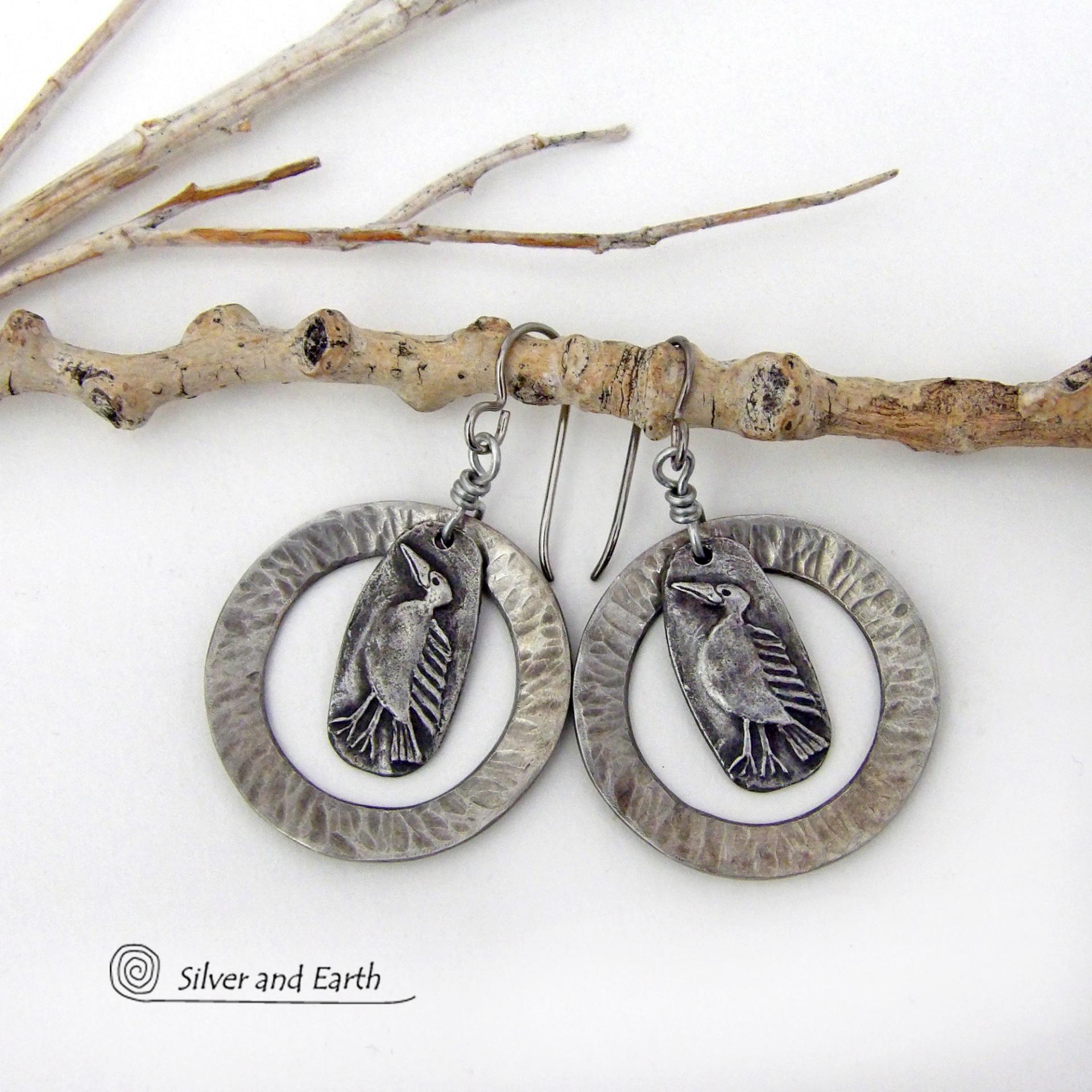 These handcrafted earrings feature silver pewter circle hoops with a hammered texture accented with silver pewter bird charms dangling in front. Lightweight and comfortable to wear, they have a casual earthy style with rustic flair that coordinates with all wardrobe types. They'll make a great gift for a nature / bird lover - or a unique addition to your own jewelry wardrobe. Handmade in the USA by Silver and Earth Jewelry.