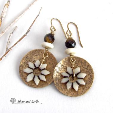 These handmade gold brass earrings have an ethnic bohemian style with an African inspired flair that makes a bold statement. They feature round brass dangles with a lightly hammered texture accented with African flower-shaped bone beads, faceted natural tiger's eye gemstones and African bone beads. Unique and fun to wear, they'll make a great gift for nature lovers and gardeners who love bohemian style jewelry. Handmade in the USA by Silver and Earth Jewelry. 