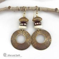 Big and bold, these handcrafted gold brass hoop earrings have a hand stamped texture and are accented with African batik bone dark brown beads with a dotted pattern, off-white bone beads and textured gold brass beads. They have an exotic ethnic and boho chic vibe that makes a striking, unique statement. Handmade in the USA by Silver and Earth Jewelry.