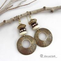 Big and bold, these handcrafted gold brass hoop earrings have a hand stamped texture and are accented with African batik bone dark brown beads with a dotted pattern, off-white bone beads and textured gold brass beads. They have an exotic ethnic and boho chic vibe that makes a striking, unique statement. Handmade in the USA by Silver and Earth Jewelry.