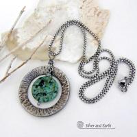 This handcrafted pendant necklace features a natural coin-shaped African turquoise gemstone framed against a hammered and oxidized silver tone pewter circle. It has a modern earthy organic style that coordinates well with all wardrobe types. The design is versatile and can be worn by either a man or woman. It will make a great gift for anyone that loves natural stone jewelry. Handmade in the USA by Silver and Earth Jewelry. 