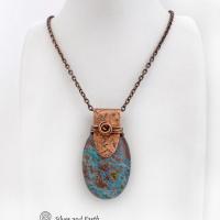 This pendant necklace features a beautiful aqua jasper gemstone with stunning hues of blue and brown accented with a hand forged copper bail with a lightly hammered texture. It's accented with twists of solid copper wire which forms a spiral in front. Unique and one-of-a-kind, it makes a great gift for a natural stone lover - or a nice addition to your own jewelry collection.