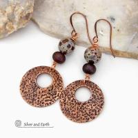 These handcrafted earrings feature round copper hoop dangles with a rustic hand stamped texture accented with natural spotted asteroid jasper and bronze glass beads. Unique and striking, they have an earthy organic flair that makes a bold statement. The jasper stones have a great natural spotted pattern with earthy shades of chocolate brown and grey. Your choice of ear wires - copper or hypoallergenic niobium.