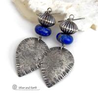 Big and bold - these earrings feature handcrafted sterling silver dangles with a rustic, organic texture accented with chunky natural blue lapis lazuli gemstones and Native style oxidized sterling silver beads with a rich, corrugated texture. They have a modern southwestern and tribal flair that makes a bold statement. Perfect for women that love artisan handcrafted southwest Santa Fe style jewelry. Handmade in the USA by Silver and Earth Jewelry - a New Mexico True Certified Business. 