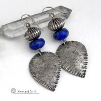 Big and bold - these earrings feature handcrafted sterling silver dangles with a rustic, organic texture accented with chunky natural blue lapis lazuli gemstones and Native style oxidized sterling silver beads with a rich, corrugated texture. They have a modern southwestern and tribal flair that makes a bold statement. Perfect for women that love artisan handcrafted southwest Santa Fe style jewelry. Handmade in the USA by Silver and Earth Jewelry - a New Mexico True Certified Business. 