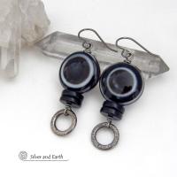 These earrings feature big natural black eye agate stones accented with black onyx and small hammered silver pewter circle dangles. When cut at the right angle, this type of agate reveals a series of concentric rings that resembles the human eye. They have a funky, modern vibe and are unique and fun to wear. They'll make a bold statement and are perfect for women that love to wear unique natural stone jewelry. 