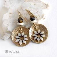 These handmade gold brass earrings have an ethnic bohemian style with an African inspired flair that makes a bold statement. They feature round brass dangles with a lightly hammered texture accented with African flower-shaped bone beads, faceted natural tiger's eye gemstones and African bone beads. Unique and fun to wear, they'll make a great gift for nature lovers and gardeners who love bohemian style jewelry. Handmade in the USA by Silver and Earth Jewelry. 