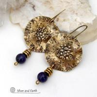 These handcrafted gold brass earrings have a rustic, hammered texture and are accented with dangling dark blue goldstones and small brass beads. They have a modern chic style with an earthy, organic vibe. Goldstone is a man-made stone of quartz sand glass infused with copper particles which creates the subtle sparkle effects. It was invented in Venice, Italy in the seventeenth century. These earrings are perfect for women that love unique, bold one-of-a-kind artisan handmade jewelry. 