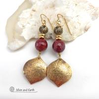 These handcrafted gold brass earrings have a hammered raw silk texture and are accented with micro-faceted burgundy mookaite gemstones, tiny brass beads and tulip flower-shaped beads. Mookaite is a unique, colorful type of jasper that is found at the Mooka Creek in Western Australia. It's known for distinct colors of burgundy, yellows, pinks, and purples. These earrings have a modern elegant chic style that coordinates beautifully with all wardrobe types. Handmade in the USA by Silver and Earth Jewelry. 