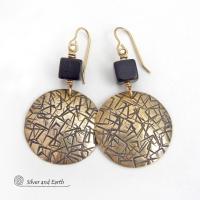 Artisan handcrafted round gold brass earrings with a hand-stamped abstract texture accented with cube-shaped matte black jasper stones on top. They have a modern contemporary vibe that coordinates beautifully with all wardrobe styles.