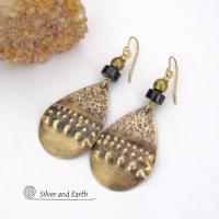 These handcrafted earrings feature textured gold brass teardrop dangles accented with matte black jasper stones and brass beads. They have an exotic, boho tribal vibe that makes a bold statement. 