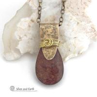 This handcrafted necklace features a natural bronzite gemstone accented with a gold brass bail. The stone has a beautiful chocolate brown hue with a subtle golden shimmer. Bronzite is a mineral that shares characteristics with rock that is found in meteorites, such as iron. It's this blend of several minerals which gives bronzite its unique mottled characteristic. The necklace has an earthy, modern style that coordinates beautifully with all wardrobe types. 