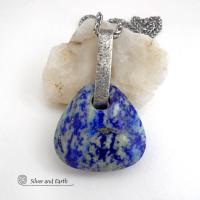 This one-of-a-kind necklace features a gorgeous, chunky and thick natural lapis lazuli gemstone accented with a handcrafted sterling silver bail with a lightly hammered organic texture. The stone is a beautiful shade of blue with white inclusions and a sprinkling of natural sparkly pyrite inclusions and a faceted finish. The stone is equally gorgeous on both sides, so I designed it to be reversible. (See all photos for alternate sides). Handmade in the USA by Silver and Earth Jewelry.