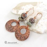 Handcrafted copper earrings with round copper hoop dangles with a rustic bumpy hammered texture accented with natural spotted asteroid jasper and gray jasper stone beads. Unique and striking, they have an earthy organic flair that makes a bold statement.
