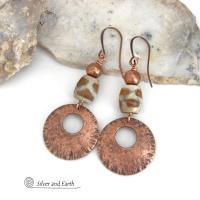 These handcrafted copper earrings have a bold, ethnic African style and flair. They feature round copper dangles with a rustic hammered texture accented with African etched giraffe print agate stones topped off with solid copper beads. Unique and striking, they'll make a bold statement. Perfect for women that love ethnic tribal style jewelry. Your choice of ear wire - copper or hypoallergenic niobium.