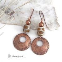 These handcrafted copper earrings have a bold, ethnic African style and flair. They feature round copper dangles with a rustic hammered texture accented with African etched giraffe print agate stones topped off with solid copper beads. Unique and striking, they'll make a bold statement. Perfect for women that love ethnic tribal style jewelry. Your choice of ear wire - copper or hypoallergenic niobium.