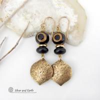 These handcrafted gold brass earrings have a contemporary modern style with an ethnic boho vibe. They feature brass drops with a lightly hammered texture accented with Tibetan eye agate gemstones, black glass and shiny brass beads. Bold and unique, they'll make a striking statement. Handmade in the USA by Silver and Earth Jewelry. 