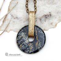 This one-of-a-kind pendant necklace has a large stunning fireworks jasper stone accented with a hand forged gold brass bail. The stone has a natural bold dramatic pattern in hues of black, gold, mint green and cream. The design is modern and bold - yet classic and always in fashion. It can be worn by either a man or women. It's reversible and can be worn on either side. (See all photos for alternate sides). Makes a great gift for a natural stone lover. Comes on a 18" antiqued gold brass chain necklace.