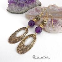 These handcrafted gold brass earrings have a hand stamped texture and are accented with faceted purple amethyst gemstones, tiny brass beads and tulip flower-shaped beads. Exotic and unique, they have an elegant chic Egyptian style vibe that makes a bold statement. They'll make a great gift for someone born in February - Amethyst is February's birthstone. Handmade in the USA by Silver and Earth Jewelry. 