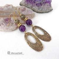 These handcrafted gold brass earrings have a hand stamped texture and are accented with faceted purple amethyst gemstones, tiny brass beads and tulip flower-shaped beads. Exotic and unique, they have an elegant chic Egyptian style vibe that makes a bold statement. They'll make a great gift for someone born in February - Amethyst is February's birthstone. Handmade in the USA by Silver and Earth Jewelry. 