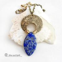A stunning natural lapis lazuli gemstone is accented with a handcrafted gold brass crescent moon in this bold exotic necklace. The stone has a beautiful blue hue with a natural matrix of white and silvery pyrite inclusions. Unique and one-of-a-kind, it has an "Old World" Egyptian style and flair that makes a striking statement.