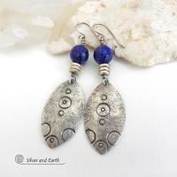  These artisan handcrafted steling silver dangle earrings have a distinct  "Egyptian inspired vibe," evoking the mystique and power of that ancient civilization. The unique design consists of sterling dangles with a hand stamped texture accented with faceted lapis lazuli gemstones. They are perfect for women that like to make a bold, eye-catching statement with their jewelry. 