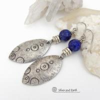  These artisan handcrafted steling silver dangle earrings have a distinct  "Egyptian inspired vibe," evoking the mystique and power of that ancient civilization. The unique design consists of sterling dangles with a hand stamped texture accented with faceted lapis lazuli gemstones. They are perfect for women that like to make a bold, eye-catching statement with their jewelry. 