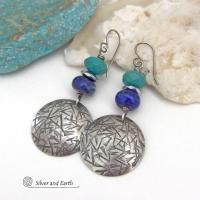 These handcrafted earrings feature sterling silver dangles with a hand stamped texture accented with faceted turquoise and lapis lazuli gemstones. Small hematite gemstones with a faceted finish were added for a touch of natural sparkle and shine. The earrings have a contemporary, modern chic style with a bit of southwestern flair. They'll coordinate beautifully with all wardrobe types - dressed up or down. Handmade in the USA by Silver and Earth Jewelry. 