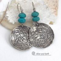 These handcrafted earrings feature large sterling silver round dangles with a hand stamped texture accented with natural turquoise gemstones with a faceted finish. Big and bold, they have a modern style with southwestern flair that looks great with all wardrobe types. Perfect for women that love large earrings and bold statement jewelry. Handmade in the USA by Silver and Earth Jewelry, a New Mexico True Certified business.