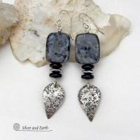 These handcrafted sterling silver earrings feature natural larvikite gemstones accented with small sterling silver dangles, black onyx and faceted silver hematite gemstones. The larvikite has a pearly, grayish black hue with iridescent flashes of light which cast off a natural shimmer & shine. They have a modern, chic contemporary style that will look great dressed up or down. Larvikite originates from the Larvik region in Norway. It's also called Norwegian moonstone and black labradorite. 