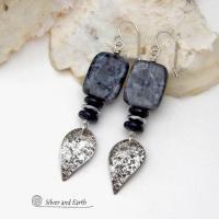 These handcrafted sterling silver earrings feature natural larvikite gemstones accented with small sterling silver dangles, black onyx and faceted silver hematite gemstones. The larvikite has a pearly, grayish black hue with iridescent flashes of light which cast off a natural shimmer & shine. They have a modern, chic contemporary style that will look great dressed up or down. Larvikite originates from the Larvik region in Norway. It's also called Norwegian moonstone and black labradorite.