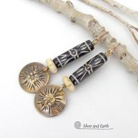 These handcrafted earrings feature African batik carved bone beads accented with textured gold brass dangles and carved bone beads. They have a boho chic tribal flair that will make a striking statement. Perfect for women that love to wear bold unique jewelry. Handmade in the USA by Silver and Earth Jewelry. 