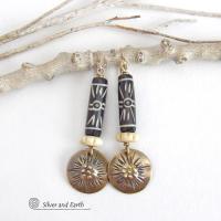 These handcrafted earrings feature African batik carved bone beads accented with textured gold brass dangles and carved bone beads. They have a boho chic tribal flair that will make a striking statement. Perfect for women that love to wear bold unique jewelry. Handmade in the USA by Silver and Earth Jewelry. 