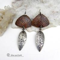 These sterling silver and copper mixed metal earrings have a modern, contemporary vibe. The copper has a dotted embossed pattern and the sterling dangles have a rustic hammered and stamped texture. Unique and versatile, the combination of metals will coordinate well with other copper and silver accessories in your wardrobe.