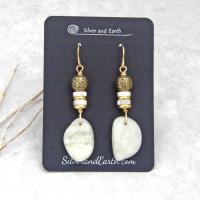 These earrings feature natural white moonstone nuggets accented with white Mother of Pearl and brass beads. They are topped off with larger brass beads that have an intricate filigree design. They have a modern chic style with a touch of exotic flair that looks great with all wardrobe types. They'll make a great gift for a natural stone lover - or a nice addition to your own jewelry collection.