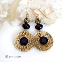 These handcrafted earrings feature gold brass dangles with a hand stamped texture accented with round black onyx gemstones dangling in front and topped off with black onyx gemstones and tulip flower-shaped beads. The round onyx stones have a faceted cut which casts off a beautiful natural sparkle and shine. They have a modern, elegant chic style that looks great dressed up or down. Perfect for women that love bold unique artisan handcrafted jewelry. Handmade in the USA by Silver and Earth Jewelry.