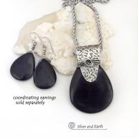 This sterling silver necklace features a black onyx gemstone accented with a handcrafted sterling silver bail with a hand stamped texture. It has a modern, contemporary style that coordinates beautifully with all wardrobe types. Coordinating earrings sold separately. 