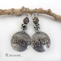 These handcrafted silver pewter earrings have a rustic, hand textured design and are accented with natural dalmatian jasper gemstones, stainless steel and vintage silver tone metal beads. They have an earthy, edgy organic style that makes a unique statement.This type of jasper is known for its spotted pattern that resembles the Dalmatian breed of dog. The matrix consists of mineral inclusions of brown iron oxide, black tourmaline & other minerals which create the natural "spots" in the stone. Handmade in th
