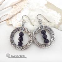 These handcrafted silver pewter hoop earrings have a hand stamped texture accented with black lava rock stones dangling in front. The stones have natural "pits" and crevices which is expected with porous lava stones. Lava stone is formed when molten rock erupts from an active volcano and comes in contact with the cool atmosphere of the Earth, which begins to solidify it. They have an earthy chic style that coordinates with all wardrobe types.
