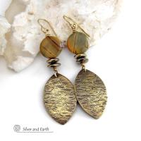 These handcrafted earrings feature textured gold brass dangles accented with natural Picasso jasper gemstones and hematite stone beads. The beads have an electroplated champagne gold tone finish which adds a touch of shimmer and shine. They have an earthy modern style that coordinates well with all wardrobe styles. Coordinating necklace is available and sold separately.