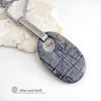 This one-of-a-kind necklace features a gorgeous natural Picasso marble gemstone accented with a hand forged sterling silver bail with a lightly hammered organic texture. The stone has earth tone shades of black, grey and some brown with an interesting matrix of abstract lines. This semiprecious stone is found only in southwest Utah. Makes a great gift for a natural stone lover - or a nice addition to your own jewelry wardrobe.