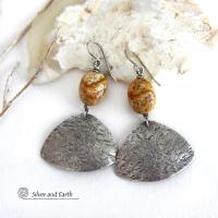 These handcrafted earrings feature natural picture jasper stones accented with textured sterling silver dangles. They have a modern, earthy design that looks great with all wardrobe styles. The stones have a natural pattern of brown streaks and black speckles against a tan background. I created the dangles out of solid sterling silver sheet; hammered them for an earth, organic texture; then oxidized them to enhance the detail. Earrings have a coordinating necklace sold separately. 