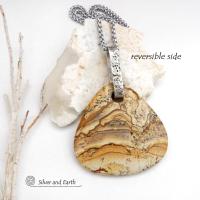 This one-of-a-kind necklace features a large stunning picture jasper stone accented with a handcrafted sterling silver bail. The stone has a beautiful natural pattern in various shades of brown, beige and gray. Big and bold, this necklace is a real statement piece - perfect for anyone that loves natural stones! 