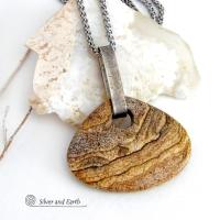 This handcrafted necklace features a large, chunky natural picture jasper stone accented with a handcrafted sterling silver bail. The stone has a beautiful natural pattern in various shades of brown, beige and gray. Big and bold, this necklace is a real one-of-a-kind statement piece - perfect for anyone that loves natural stones! It's reversible and can be worn on either side. Coordinating earrings sold separately. Handmade in the USA by Silver and Earth Jewelry.