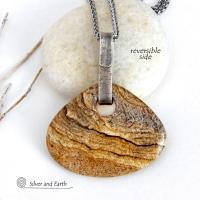 This handcrafted necklace features a large, chunky natural picture jasper stone accented with a handcrafted sterling silver bail. The stone has a beautiful natural pattern in various shades of brown, beige and gray. Big and bold, this necklace is a real one-of-a-kind statement piece - perfect for anyone that loves natural stones! It's reversible and can be worn on either side. Coordinating earrings sold separately. Handmade in the USA by Silver and Earth Jewelry.