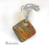 This one-of-a-kind necklace features a natural red creek jasper stone accented with a hand forged sterling silver bail. The stone has a beautiful natural pattern in earthy hues of mossy greens, brick red and orange. Great colors for your fall wardrobe! It's reversible and can be worn on either side. (See all photos for alternate sides). It will make a great gift for anyone that loves natural stones! The design is unisex so it could be worn by a man or woman.